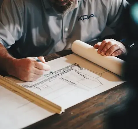 Tavolo da disegno con planimetrie e strumenti di progettazione